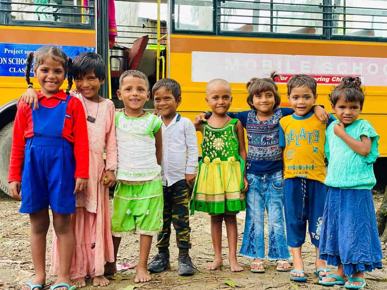 Children from underprivileged communities stand in front of the Aasraa Trust’s Mobile Learning Centre bus in Dehradun, an ASED-supported initiative providing non-formal education, nutrition, and healthcare to out-of-school children